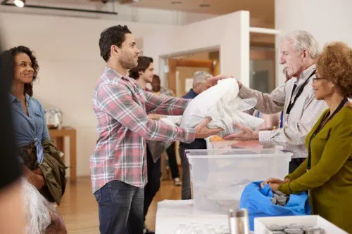 People donating clothes to charity volunteers